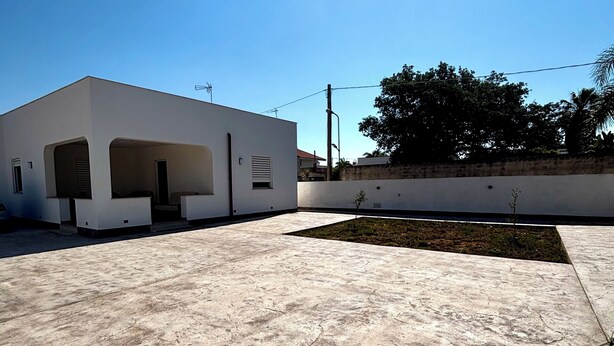 A modern building with a flat roof and a concrete patio area. - Villa Amurusa | 300 m from the sea, with a veranda, barbecue, and private garden (Mazara del Vallo)