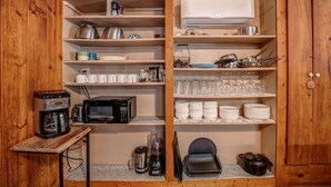 Een keuken met een koffiezetapparaat, magnetron, blender en een fornuis.