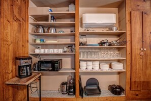 A kitchen with a coffee maker, microwave, blender, and a stove. - Historic Pioneer Cabin with Creek Views in Talking Rock, Georgia (Talking Rock)