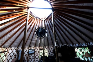 A yurt with a circular entrance, a hanging dreamcatcher, and a mounted television. - Glamping Yurt with Firepit, Hammock & Wood Stove in Garden Valley, Idaho (Garden Valley)