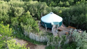 A geodesic dome structure surrounded by dense forest, with a wooden deck and a small staircase leading to the entrance. - Glamping Yurt with Firepit, Hammock & Wood Stove in Garden Valley, Idaho (Garden Valley)