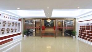 Rebedor d'hotel amb entrada de vidre, una taquilla d'informació i una paret amb cartells informatius.