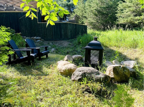 A garden area with outdoor seating, a lantern, and large rocks.