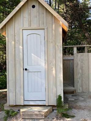 A wooden shed with a white door and a small porch. - Forest Gazebo in Hastings, Ontario (Hastings)