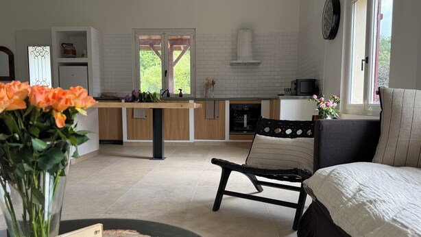 A modern kitchen with a dining area, a sofa, and a bed. - SOLEO Vacation Home (Solférino)
