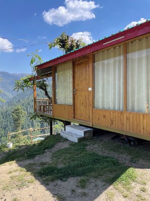 A wooden cabin with a balcony, a door, and a window. - Tranquil 1-bedroom cabin in marvelous Kullu for a cozy stay (kullu)