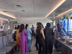 A hotel lobby with seating areas and a buffet setup. - Hotel Brahmaputra Madhukalya (Guwahati)