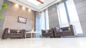 Una hall moderna con due divani, un tavolino da caffè e un quadro incorniciato appeso al muro.