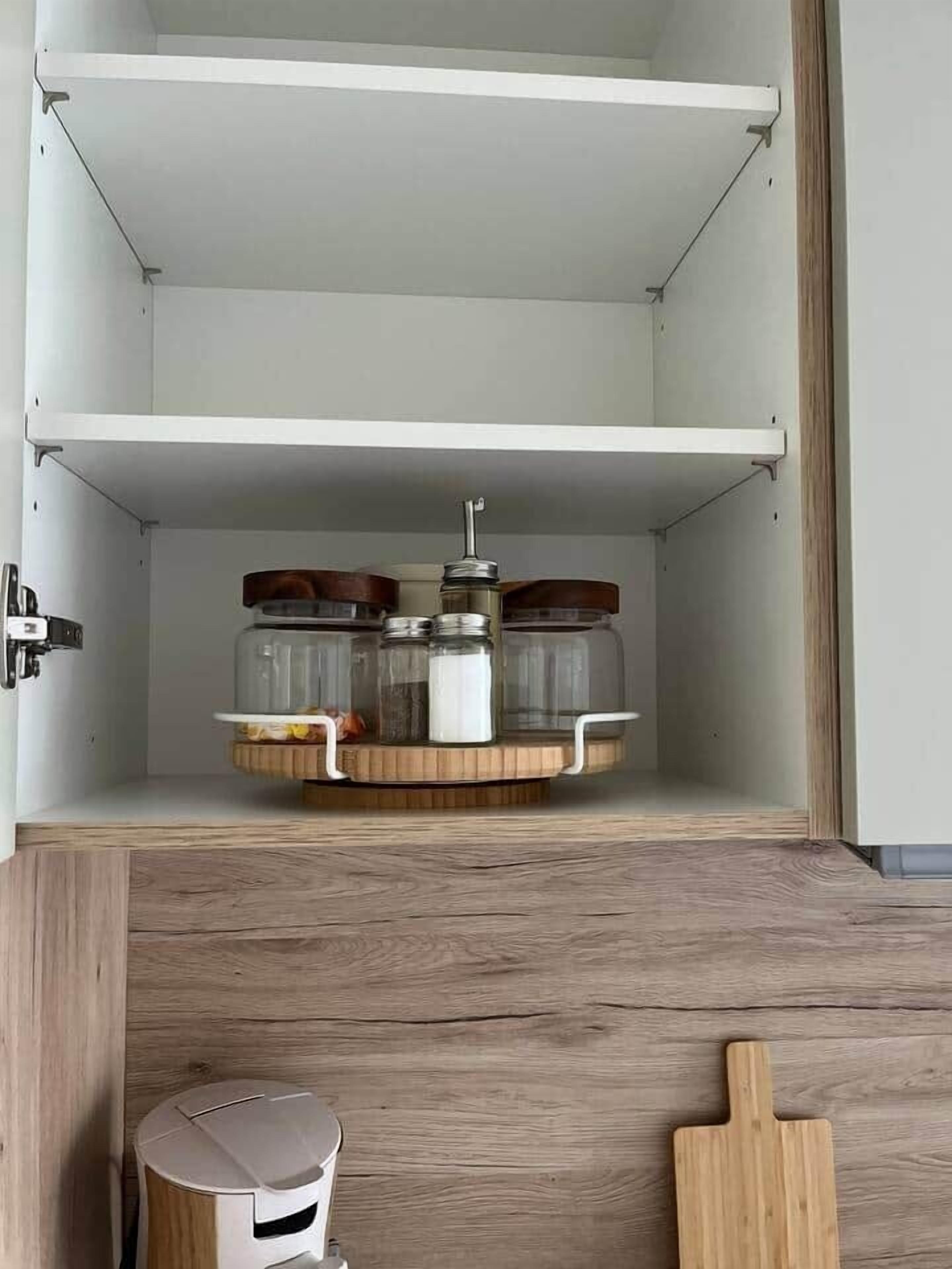 An open cabinet with a wooden base, containing jars and a container on a circular tray.