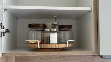 An open cabinet with a wooden base, containing jars and a container on a circular tray.