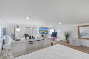 A modern bedroom with a large bed, a bedside table, a TV, and a window. - Modern and Inviting Tiny Home Retreat with Resort-Style Pool and Amenities Near Fredericksburg, TX (Fredericksburg)