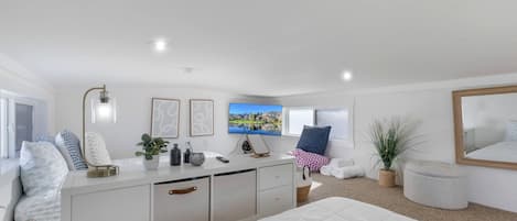 A modern bedroom with a large bed, a bedside table, a TV, and a window.