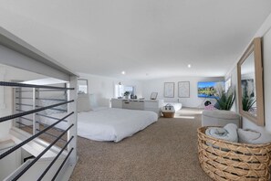 A bedroom with a large bed, a desk, a chair, a small table, and a wicker basket. - Modern and Inviting Tiny Home Retreat with Resort-Style Pool and Amenities Near Fredericksburg, TX (Fredericksburg)