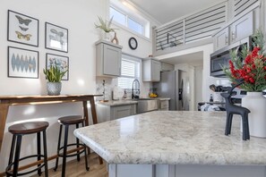Een moderne keuken met een groot eiland, barkrukken en een decoratieve herten.