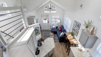A modern loft-style apartment with a kitchen, dining area, and living room.