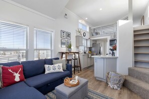 A modern apartment with a living room, kitchen, and dining area. - Modern and Inviting Tiny Home Retreat with Resort-Style Pool and Amenities Near Fredericksburg, TX (Fredericksburg)