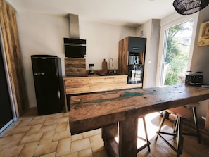 A kitchen with a wooden countertop, a built-in oven, and a refrigerator.