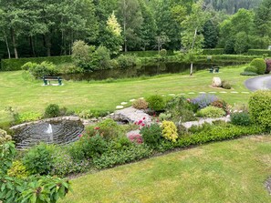 A well-maintained garden with a pond, benches, and a variety of plants. - Lapland Log Cabins on a Beautiful Property with a Spa and Pond (Granges-Aumontzey)