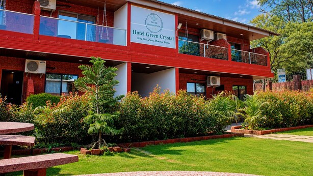 A two-story hotel with a red exterior, balconies, and a sign that reads 'Hotel Green Crystal.' - Hotel green crystal (Mahabaleshwar)