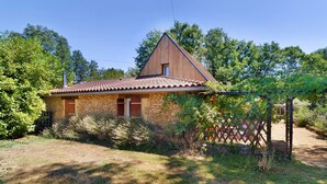 A stone house with a tiled roof, surrounded by greenery and a fenced garden. - Apartment 'La Clésinerie' with Private Pool, Private Terrace and Wi-Fi (Badefols-sur-Dordogne)