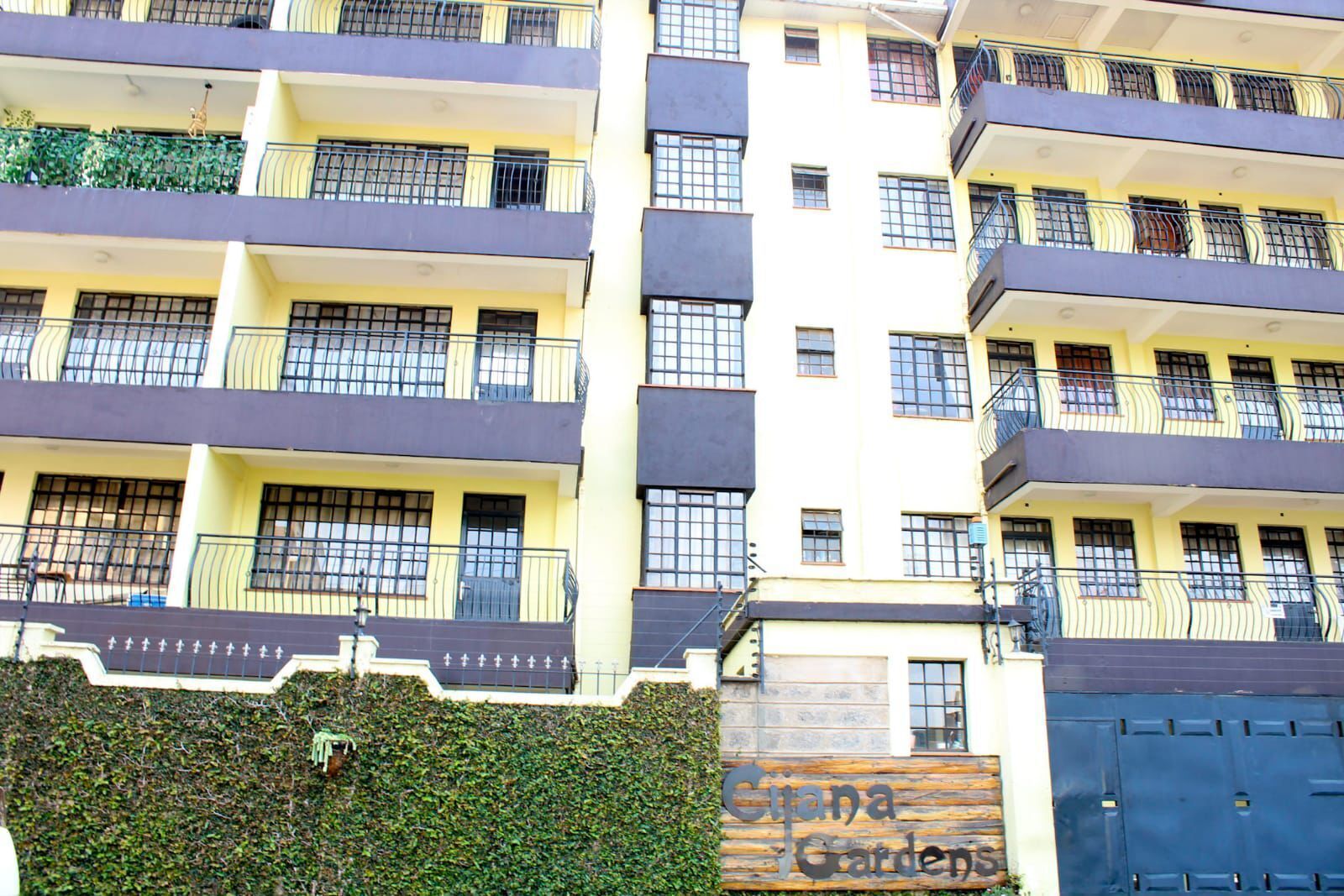 Un immeuble à plusieurs étages doté de balcons, d’une entrée sécurisée et d’une enseigne indiquant « Cijana Gardens ».