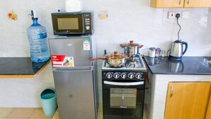 Eine Küche mit Kühlschrank, Mikrowelle, Herd und Backofen.
