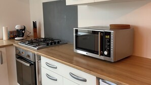 A modern kitchen with a microwave, stove, oven, and cabinets.