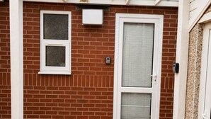 A brick exterior with a white-framed door and a window.