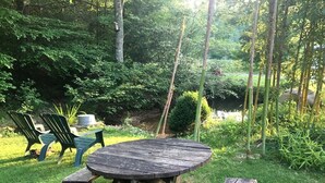 A wooden picnic table with benches in a lush garden setting.