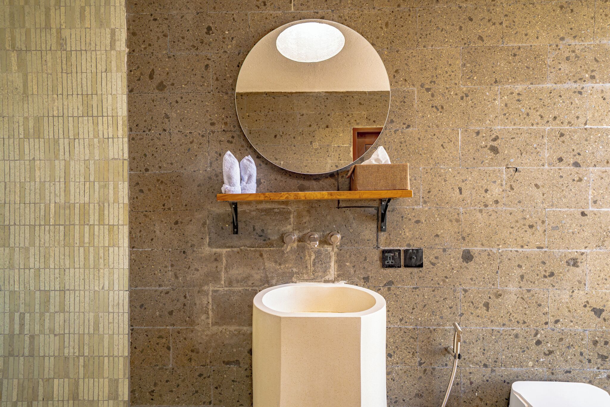 A bathroom with a large sink, a mirror, and a towel rack.