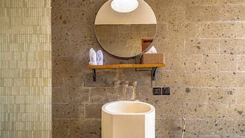 A bathroom with a large sink, a mirror, and a towel rack.