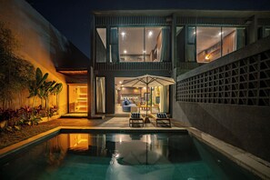 Una casa moderna con piscina, mobiliario exterior y sauna.