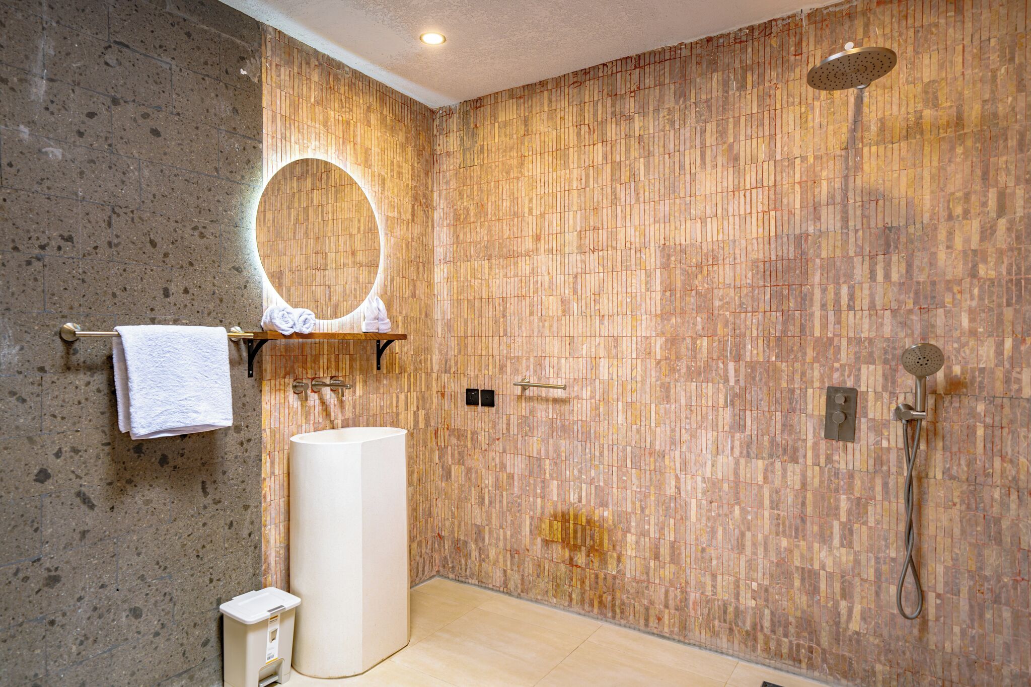 Uma casa de banho moderna com um espelho grande, uma pia e um chuveiro.