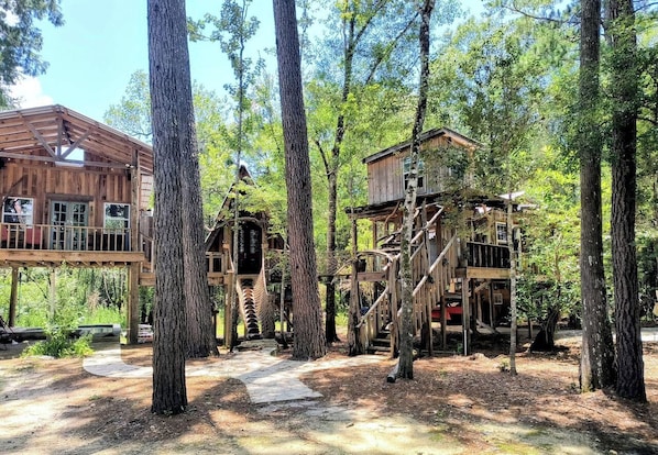 A wooden cabin with a deck and a treehouse in a forested area. - Off-Grid Nature Retreat Near Satilla River, Georgia (WAYNESVILLE)
