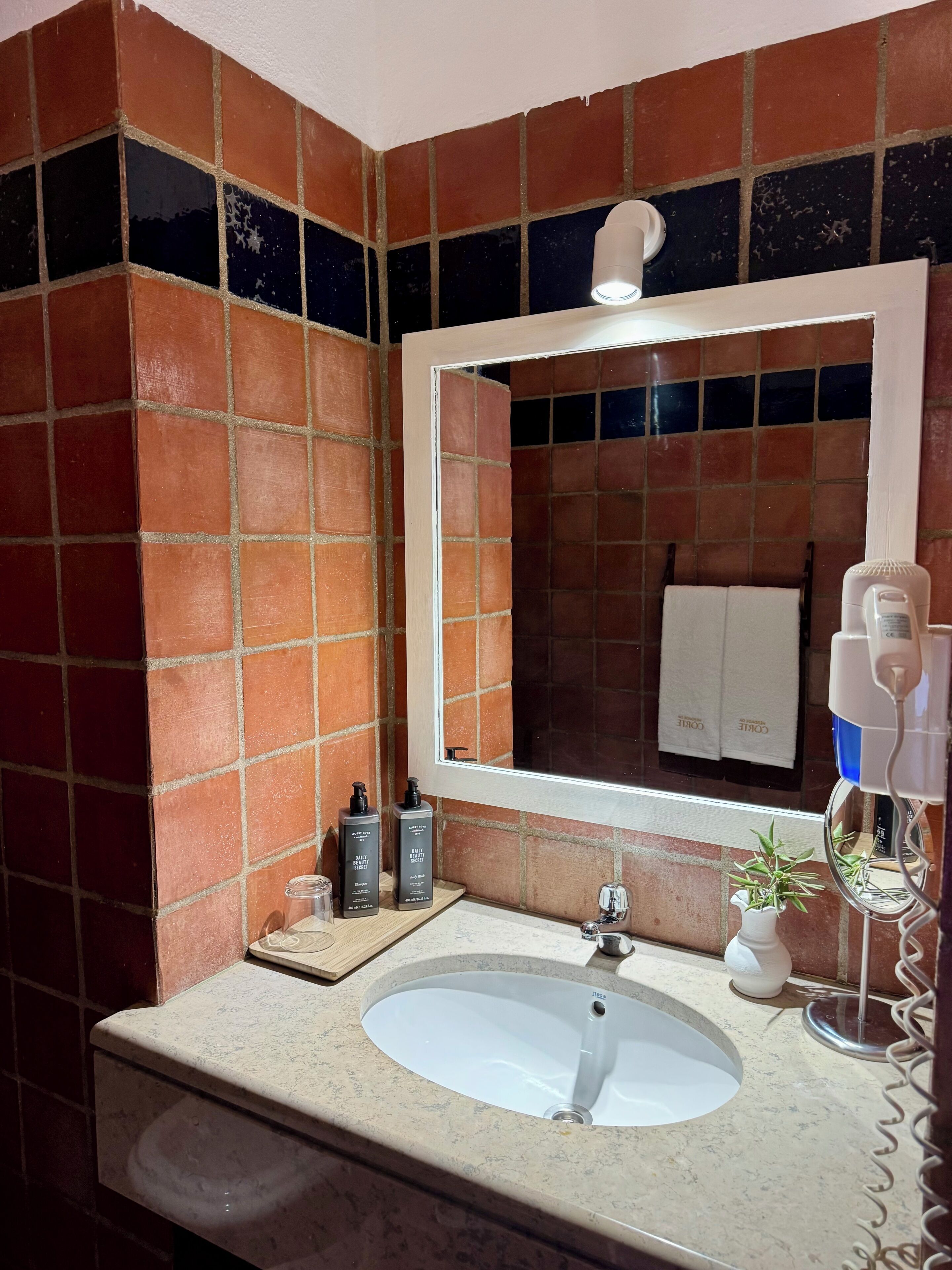 A bathroom with a white sink, a mirror, and a towel rack.