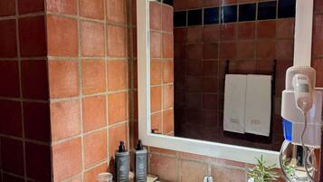 A bathroom with a white sink, a mirror, and a towel rack.