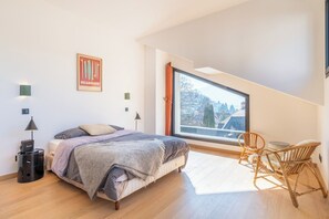 A bedroom with a bed, a chair, a window, and a lamp. - Stunning Villa in Menton, (Menthon saint bernard)