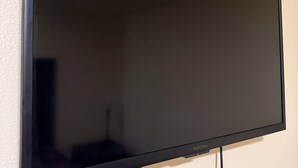 A flat-screen TV mounted on a wall with a visible cable. - Spacious 3-bedroom apartment with AC near Portland (Gresham)