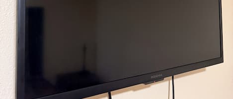 A flat-screen TV mounted on a wall with a visible cable.