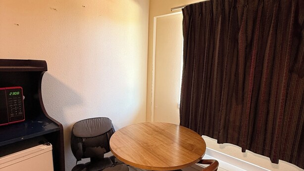 A small room with a round wooden table, two chairs, a microwave, and a refrigerator. - Spacious 3-bedroom apartment with AC near Portland (Gresham)
