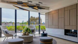 A modern living room with a large window, a fireplace, and a view of the city. - CASA DELUXE #5 - Pool Gym Sauna Spa City Views Parking (South Yarra)