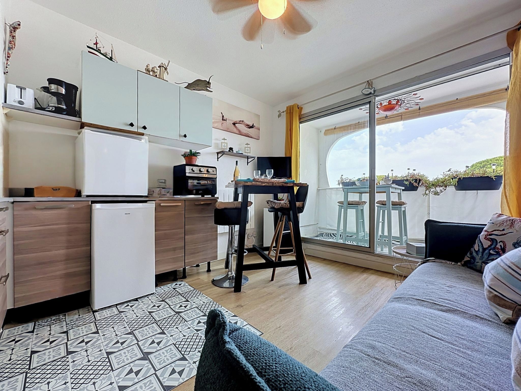 A compact living space with a kitchenette, a dining area, and a sofa.