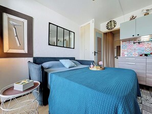 A bedroom with a bed, a bedside table, a mirror, and a wardrobe. - La Santa Maria by Interhome (Port Camargue)