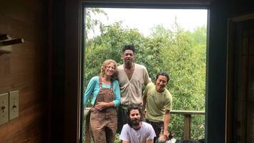 Un grupo de personas en un balcón con baranda de madera, contemplando un paisaje verde y exuberante.