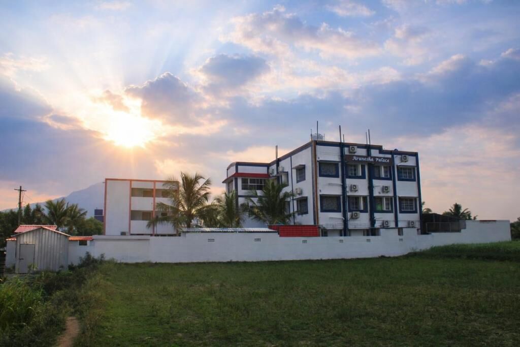 A multi-story building with a sign reading 'Arunesh Palace.'