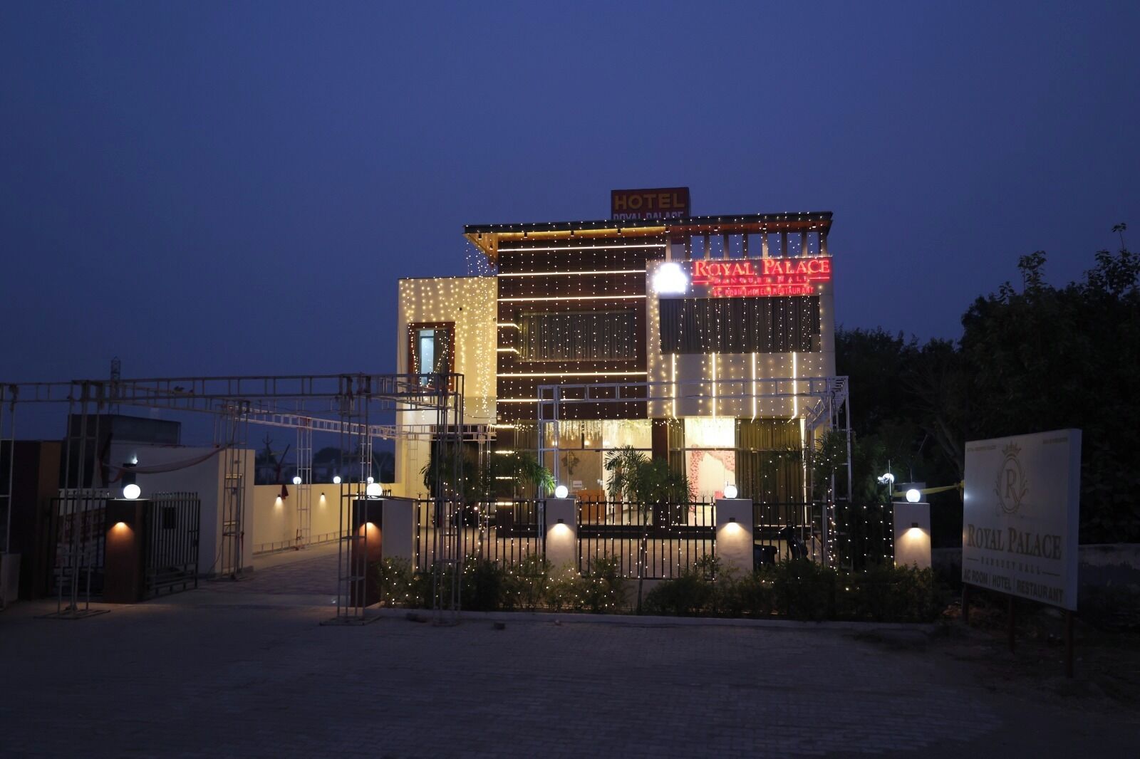 A hotel with a sign reading 'Royal Palace' and a sign indicating it is a hotel and restaurant.