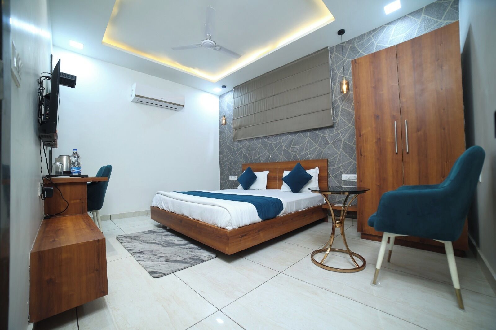 A modern bedroom with a bed, a desk, a chair, and a wardrobe.