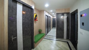 A hotel corridor with doors numbered 104 and 110, a small green plant, and a statue on the wall. - HOTEL ROYAL PALACE (Bhiwani)