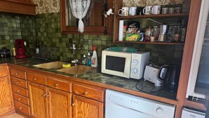 Une cuisine avec des meubles de rangement en bois, un four à micro-ondes, un grille-pain et un lave-vaisselle.