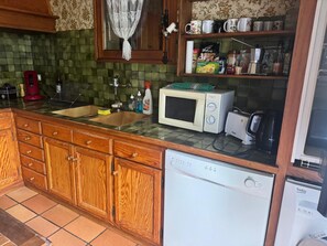 Eine Küche mit Holzausstattung, einer Mikrowelle, einem Toaster und einem Geschirrspüler.